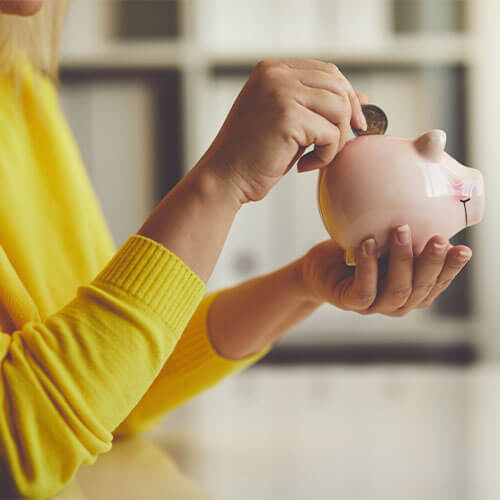 Woman putting money in a piggybank